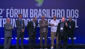 Oswaldo de Oliveira no 2º Fórum Brasileiro dos Treinadores de Futebol, com Carlo Ancelotti e Emerson Leão ao fundo - Reprodução/YouTube/FBTF