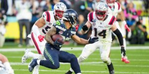 George Holani, running back do Seattle Seahawks, tenta passar pela marcação do New England Patriots, durante o Super Bowl LX - Todd Rosemberg/NFL