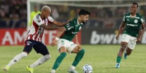 Flaco López (centro), do Palmeiras, tenta passar pela marcação do Junior Barranquilla, em jogo da Libertadores - Cesar Greco/Palmeiras